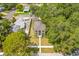 A well maintained home is framed by lush trees and manicured grounds, as seen from an aerial perspective at 7125 6Th N Ave, St Petersburg, FL 33710