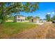 Exterior view of a two-story home and detached garage, featuring a large grassy backyard at 7125 6Th N Ave, St Petersburg, FL 33710