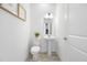 Clean powder room with a modern pedestal sink and white fixtures, plus minimalist decor at 7125 6Th N Ave, St Petersburg, FL 33710