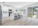 Modern white kitchen with stainless steel appliances, an island with seating, and sliding glass doors at 7125 6Th N Ave, St Petersburg, FL 33710