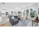 Bright living room with a gray sofa, modern rug, and views into the kitchen with breakfast bar seating at 7125 6Th N Ave, St Petersburg, FL 33710