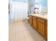 Bathroom featuring a shower-tub combination, light tile floors, and a wood vanity at 10011 Tranquility Way, Tampa, FL 33625