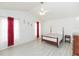 Bright bedroom with wood-look floors, ceiling fan, and natural light streaming through large windows at 10011 Tranquility Way, Tampa, FL 33625