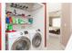 Laundry room with stacked washer and dryer, with a storage shelf above and a bedroom in background at 10011 Tranquility Way, Tampa, FL 33625