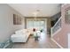 Bright living room features a modern chandelier, sliding glass door and comfortable white couch at 10011 Tranquility Way, Tampa, FL 33625