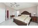 The primary bedroom features wood-look floors, a ceiling fan, a large window, and a large bed at 10011 Tranquility Way, Tampa, FL 33625