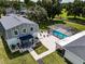 Aerial view of a grey barn-style home with a screened-in pool, stone patio, and manicured lawn at 11112 Browning Rd, Lithia, FL 33547