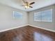 Bright bedroom features wood flooring, neutral walls, base molding, a ceiling fan and many windows at 1218 74Th N St, St Petersburg, FL 33710