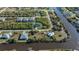 Stunning aerial view of a home situated on a waterfront canal, surrounded by lush greenery and neighboring properties at 14207 Fort Worth Cir, Port Charlotte, FL 33981