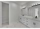 Bathroom featuring a double sink vanity, dark hardware, and a walk-in closet with wire shelving at 14207 Fort Worth Cir, Port Charlotte, FL 33981