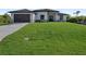 Modern one-story home with a dark roof, a two-car garage, and a well-manicured front yard at 14207 Fort Worth Cir, Port Charlotte, FL 33981