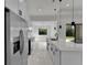 Modern white kitchen featuring stainless steel appliances, quartz countertops, and stylish pendant lighting at 14207 Fort Worth Cir, Port Charlotte, FL 33981