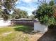 The home's fenced backyard includes green grass, mature trees, and a storage shed at 1511 Valencia St, Clearwater, FL 33756