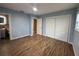 Comfortable bedroom with closet storage, wood-look floors, light blue walls, and a ceiling fan at 1511 Valencia St, Clearwater, FL 33756