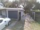 View of the house's driveway with a garage and a white car at 1511 Valencia St, Clearwater, FL 33756