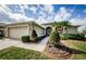 Inviting home with a two-car garage, arched entryway, a patterned walkway, and lush, manicured landscaping at 1727 Lakestone Dr, Trinity, FL 34655