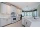 Well-lit kitchen with white appliances, white cabinets, and a view of the breakfast nook at 1727 Lakestone Dr, Trinity, FL 34655