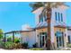 Beautiful exterior of clubhouse with tropical landscaping and covered entryway, under sunny blue skies at 17437 Haysack Ter, Lakewood Ranch, FL 34211