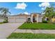 A charming single-story home featuring a three-car garage, well-manicured lawn, and lush landscaping at 18521 Bittern Ave, Lutz, FL 33558