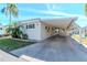 Exterior view of a home with a covered carport, showing ample parking space and tidy landscaping at 18675 Us Highway 19 N # 217, Clearwater, FL 33764