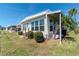 Charming home exterior showcasing manicured lawn, mature landscaping, and light siding, creating inviting curb appeal at 18675 Us Highway 19 N # 217, Clearwater, FL 33764