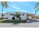 Charming single-story home featuring a covered carport and well-maintained landscaping, under a clear blue sky at 18675 Us Highway 19 N # 217, Clearwater, FL 33764
