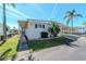 Exterior featuring well-maintained landscaping, carport, and neutral siding, providing a cozy and welcoming home at 18675 Us Highway 19 N # 217, Clearwater, FL 33764