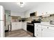 Well-lit kitchen featuring white cabinetry, stainless steel appliances, and a tiled backsplash at 18675 Us Highway 19 N # 217, Clearwater, FL 33764