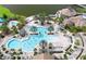 Aerial view of the community's resort-style pool with plenty of lounge chairs, palm trees and lush green spaces at 19410 Indian Rock Pl, Lakewood Ranch, FL 34211