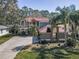 A beautiful two-story home features mature landscaping, a brick facade, and an expansive driveway at 2075 Warwick Dr, Oldsmar, FL 34677