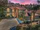 Beautiful two-story home with a brick facade and a well-manicured lawn set against a dramatic pink sky at 2075 Warwick Dr, Oldsmar, FL 34677