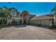 Exterior view of the home showcasing the large three-car garage and inviting front entrance with a stone facade at 2075 Warwick Dr, Oldsmar, FL 34677