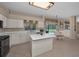 Bright kitchen boasts white cabinetry, island, and views of the pool area at 2075 Warwick Dr, Oldsmar, FL 34677