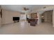 Bright living room featuring tile floors, a ceiling fan, and a comfortable seating arrangement with a TV at 2075 Warwick Dr, Oldsmar, FL 34677