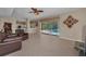 Open living room featuring tile flooring, a ceiling fan, and sliding glass doors to the pool area at 2075 Warwick Dr, Oldsmar, FL 34677