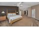 Spacious main bedroom featuring carpeted floor, a fan, and a king size bed with wooden bedframe at 2075 Warwick Dr, Oldsmar, FL 34677