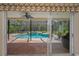 Relaxing view through sliding glass doors to the screened-in pool with water features and an outdoor seating area at 2075 Warwick Dr, Oldsmar, FL 34677