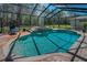 Screened pool with spa and water features surrounded by a brick patio and lush tropical landscape at 2075 Warwick Dr, Oldsmar, FL 34677