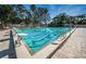 Sparkling outdoor swimming pool with lap lanes, diving blocks, and a paved deck area for lounging at 2075 Warwick Dr, Oldsmar, FL 34677