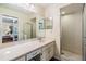 Bathroom with a large mirror, white cabinets, and a tiled shower behind a glass door at 2263 Citrus Ct, Clearwater, FL 33763