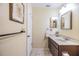 Traditional bathroom with a brown vanity, framed art, and neutral tile flooring at 2263 Citrus Ct, Clearwater, FL 33763