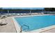 A community pool, with deck chairs and tables, overlooks the lake at 2263 Citrus Ct, Clearwater, FL 33763