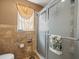 Elegant shower featuring decorative glass doors and stylish travertine tile surround at 2300 S Shore Se Dr, St Petersburg, FL 33705