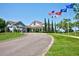 Stunning community clubhouse entrance with lush landscaping, flags, and a welcoming circular driveway at 2348 Rolling View Dr, Spring Hill, FL 34606
