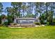 Welcoming Timber Pines community entrance with lush landscaping, flowers, and mature trees at 2348 Rolling View Dr, Spring Hill, FL 34606