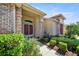 Inviting home entrance featuring brick columns, arched window, and well-manicured landscaping at 2348 Rolling View Dr, Spring Hill, FL 34606