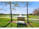 Serene lake view with a water fountain and a bench for relaxing along the landscaped path at 2348 Rolling View Dr, Spring Hill, FL 34606