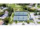 Aerial view of well-maintained community tennis courts surrounded by lush greenery and residences at 2348 Rolling View Dr, Spring Hill, FL 34606