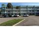 Three-story condominium building with white balconies, aqua accents, and parking, under a clear blue sky at 2455 Finlandia Ln # 3, Clearwater, FL 33763