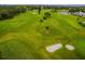 Aerial view of a lush green golf course with sand traps, water features, and mature trees at 2455 Finlandia Ln # 3, Clearwater, FL 33763